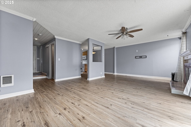 unfurnished living room featuring baseboards, ornamental molding, a ceiling fan, a textured ceiling, and wood finished floors
