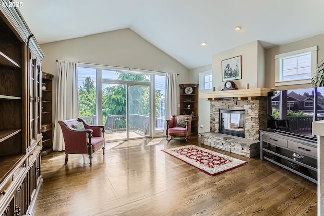 sitting room with a fireplace, healthy amount of natural light, wood finished floors, and high vaulted ceiling