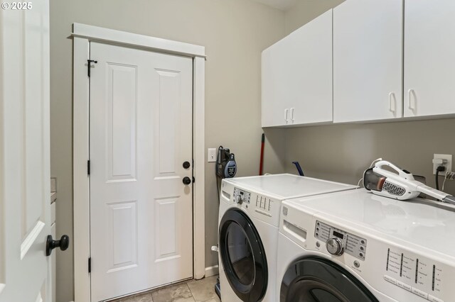 clothes washing area featuring cabinet space, washing machine and clothes dryer, and light tile patterned floors