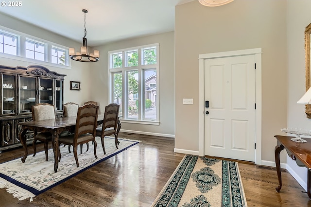 dining room with a chandelier, healthy amount of natural light, baseboards, and wood finished floors