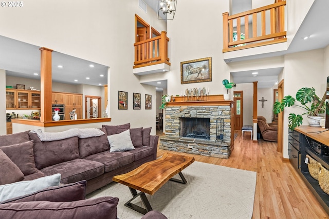 770 N Moss St, Lowell, OR 97452 - living area featuring a towering ceiling, light wood-type flooring, a fireplace, recessed lighting, and ornate columns