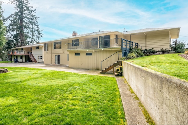 back of property with stairway, a lawn, a chimney, and a patio area