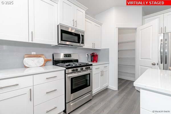 2747 Woodfern Ter Lot 57, Eugene, OR 97403 - kitchen featuring stainless steel appliances, light countertops, white cabinetry, and light wood-style floors