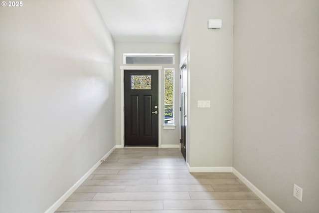 doorway to outside with light wood-style floors and baseboards
