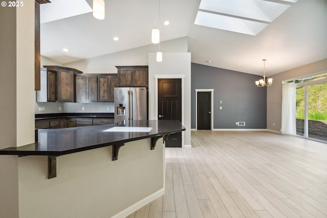 kitchen with stainless steel fridge with ice dispenser, a chandelier, dark brown cabinets, baseboards, and high vaulted ceiling