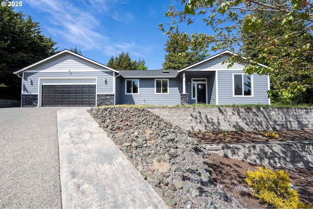 ranch-style home with concrete driveway, a garage, and stone siding