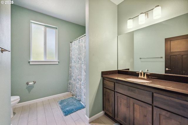 full bathroom featuring vanity, toilet, wood finished floors, and baseboards