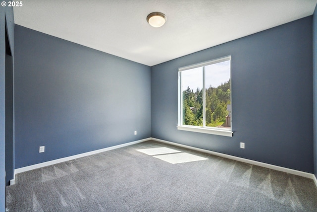 empty room featuring carpet floors and baseboards