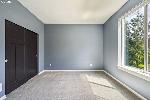 unfurnished bedroom with multiple windows, carpet, and baseboards