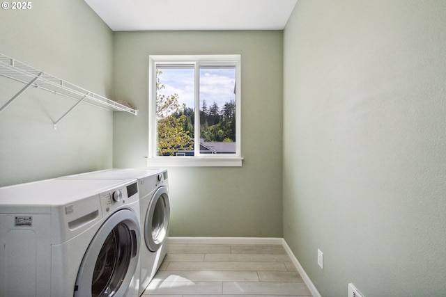 laundry room with separate washer and dryer and baseboards