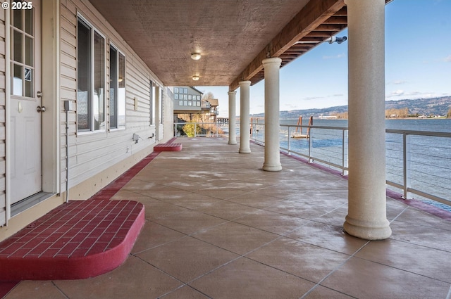 view of patio / terrace with a water view and a balcony