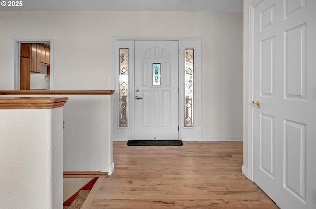 entrance foyer with baseboards and light wood-style flooring