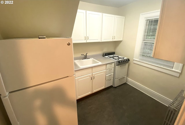 kitchen with white cabinetry, sink, refrigerator, and white gas range oven