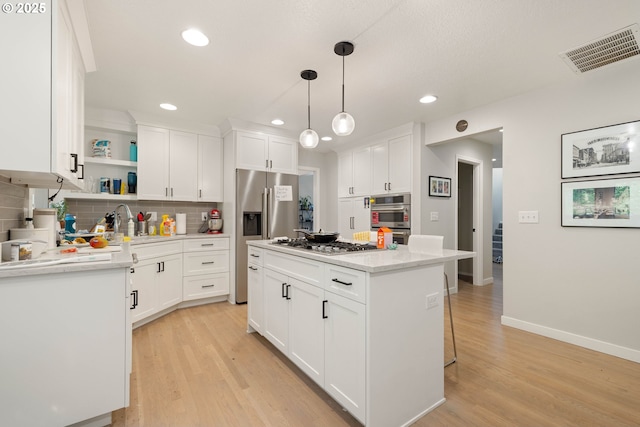 8326 SW 64th Ave, Portland, OR 97219 - kitchen with appliances with stainless steel finishes, decorative backsplash, light wood-style floors, open shelves, and white cabinets