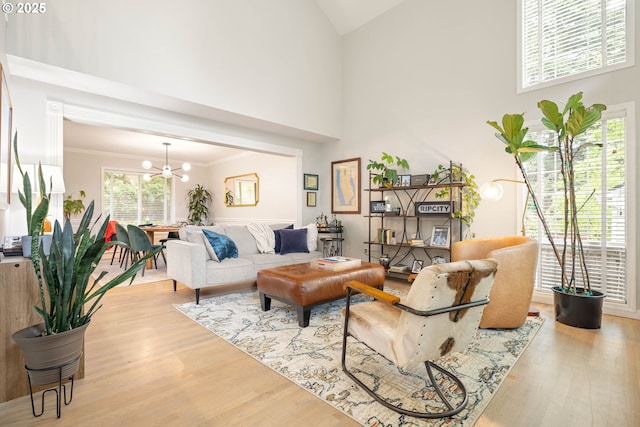 8326 SW 64th Ave, Portland, OR 97219 - living area with a chandelier, high vaulted ceiling, wood finished floors, and ornamental molding