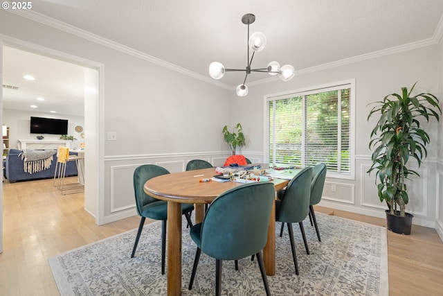 8326 SW 64th Ave, Portland, OR 97219 - dining room featuring a chandelier, crown molding, light wood finished floors, a wainscoted wall, and a decorative wall