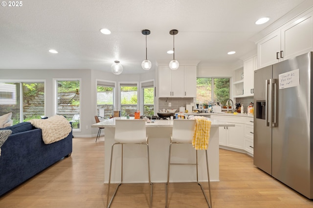 8326 SW 64th Ave, Portland, OR 97219 - kitchen with stainless steel fridge, a sink, light wood finished floors, light countertops, and recessed lighting