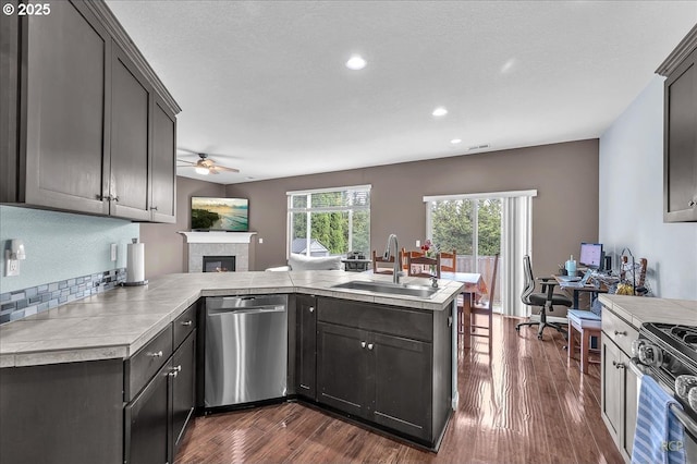 51568 SW S Fork Loop, Scappoose, OR 97056 - kitchen with dishwasher, a sink, a ceiling fan, a fireplace, and dark wood-style floors