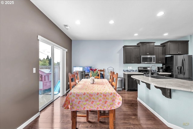 51568 SW S Fork Loop, Scappoose, OR 97056 - kitchen featuring appliances with stainless steel finishes, a sink, light countertops, a breakfast bar area, and recessed lighting