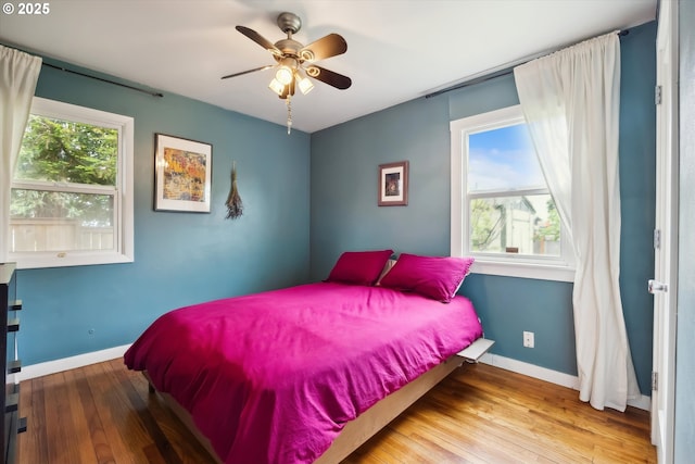 bedroom featuring wood finished floors, baseboards, and ceiling fan