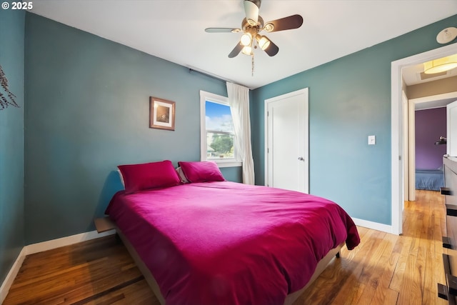 bedroom with baseboards, wood-type flooring, and a ceiling fan