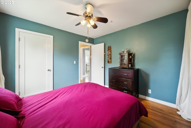 bedroom with wood finished floors, baseboards, and ceiling fan