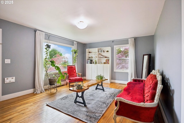 living area with baseboards and wood finished floors