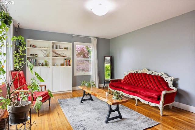 living area with wood-type flooring and baseboards