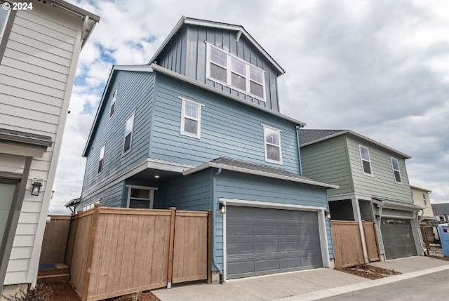 view of front of house with a garage, board and batten siding, and fence