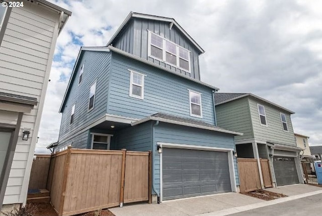 view of front of house featuring a garage, board and batten siding, and fence