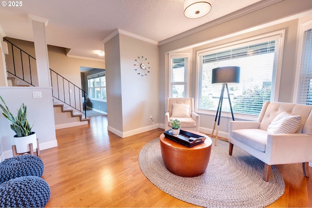 sitting room with hardwood / wood-style flooring, crown molding, a textured ceiling, and a healthy amount of sunlight