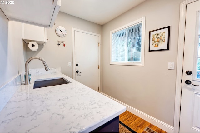 kitchen with sink, white cabinetry, and hardwood / wood-style floors