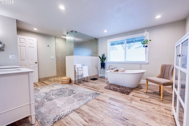 bathroom featuring separate shower and tub, hardwood / wood-style flooring, and vanity