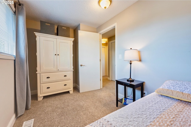 bedroom with light carpet and a textured ceiling