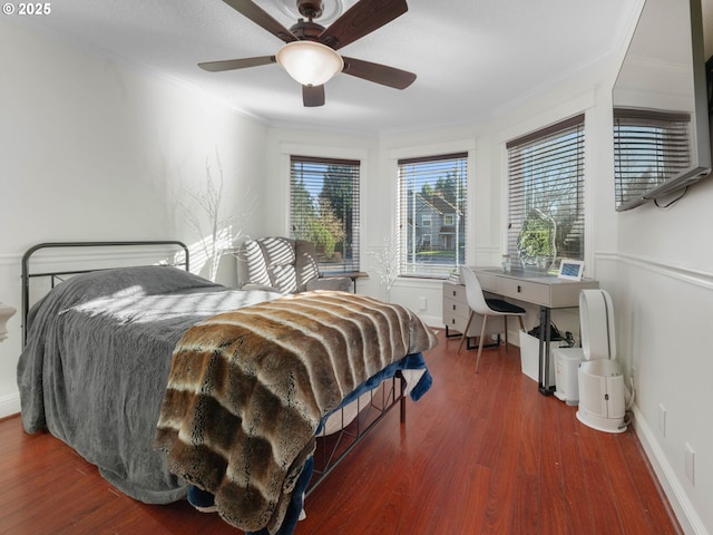 bedroom with ceiling fan, crown molding, and dark hardwood / wood-style floors