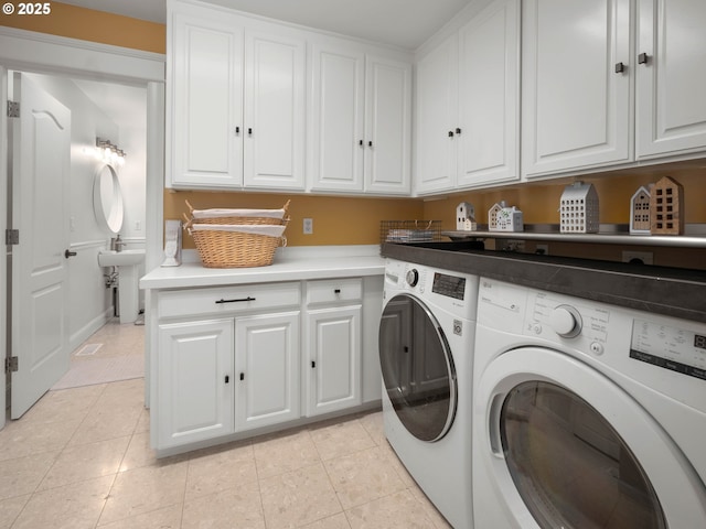 clothes washing area with cabinets, separate washer and dryer, and light tile patterned floors