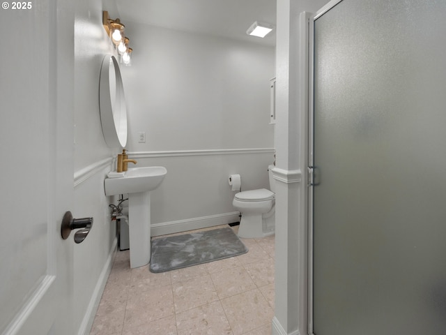 bathroom with tile patterned floors, sink, a shower with shower door, and toilet