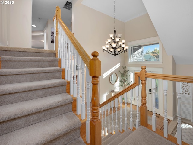 stairway featuring wood-type flooring and an inviting chandelier