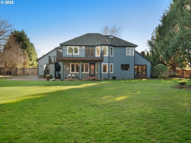 back of house featuring a lawn, a balcony, and a patio