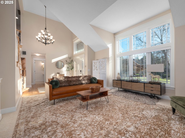 living room with a high ceiling, light colored carpet, and a notable chandelier