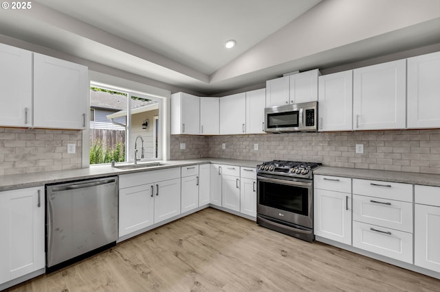 1633 N Q St, Washougal, WA 98671 - kitchen featuring appliances with stainless steel finishes, vaulted ceiling, light countertops, light wood-style floors, and white cabinets