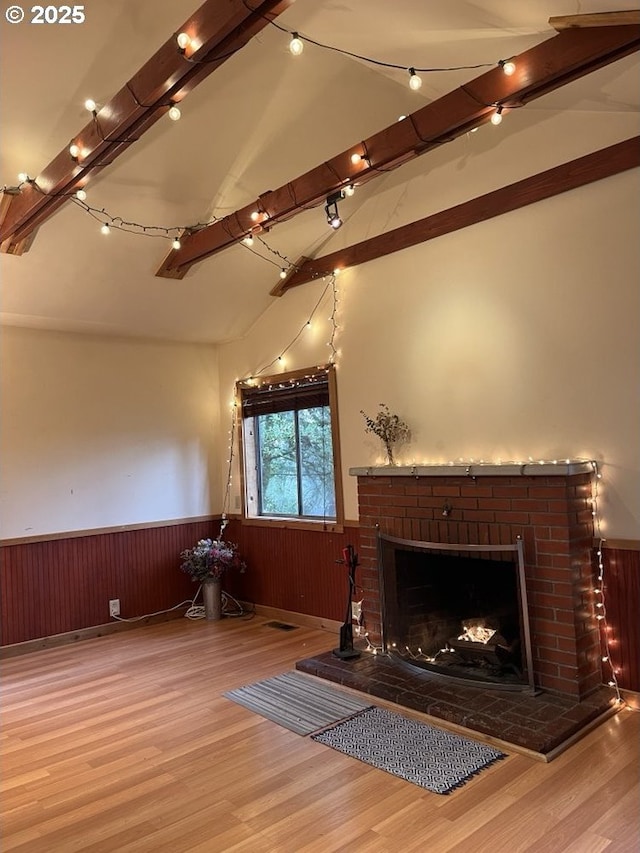 sitting room featuring hardwood / wood-style floors, vaulted ceiling with beams, and a fireplace