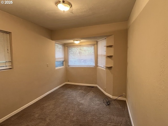 carpeted spare room featuring a textured ceiling