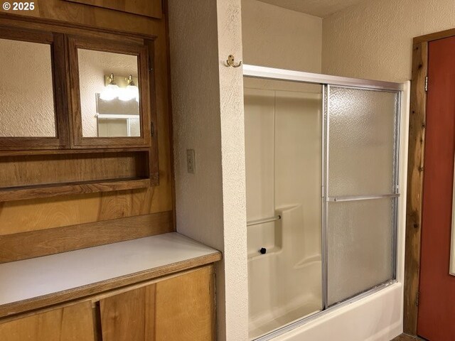 bathroom with bath / shower combo with glass door and vanity