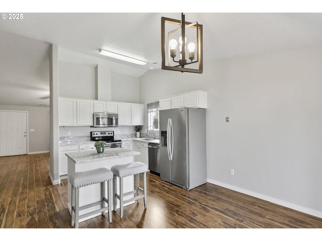 kitchen with baseboards, high vaulted ceiling, a center island, dark wood finished floors, and appliances with stainless steel finishes