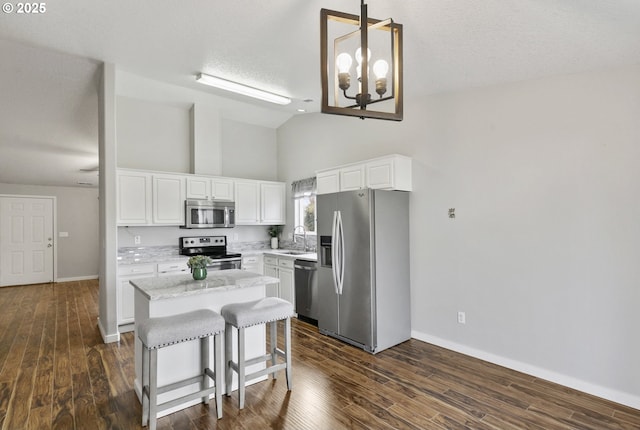 516 SE 8th Pl Unit H17, Battle Ground, WA 98604 - kitchen with baseboards, high vaulted ceiling, a center island, dark wood finished floors, and appliances with stainless steel finishes