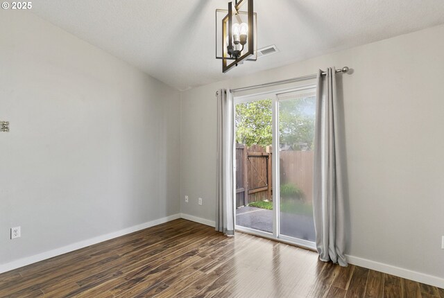 516 SE 8th Pl Unit H17, Battle Ground, WA 98604 - spare room featuring dark wood-style flooring, baseboards, visible vents, and an inviting chandelier