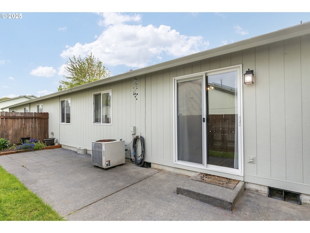 rear view of property with ac unit, a patio area, and fence