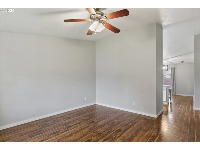 unfurnished room featuring baseboards, a ceiling fan, and dark wood-style flooring