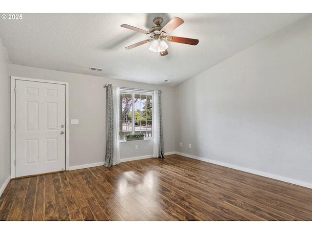 spare room featuring baseboards, a ceiling fan, wood finished floors, and visible vents